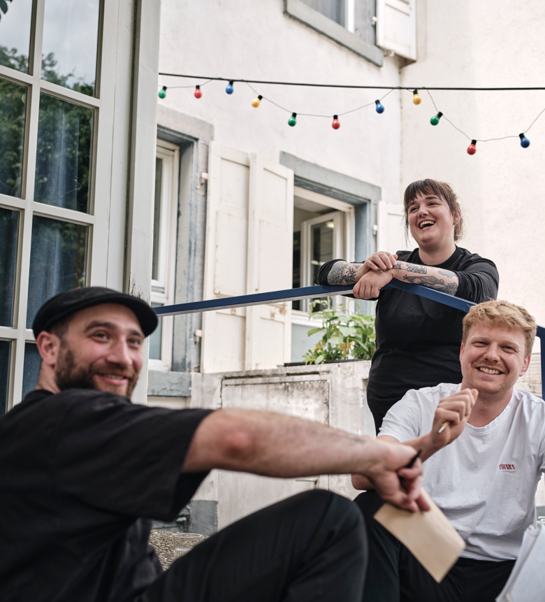 Bild von xelware: Drei Team-Mitglieder des Sterne-Restaurants Haware sitzen vorm Restaurant