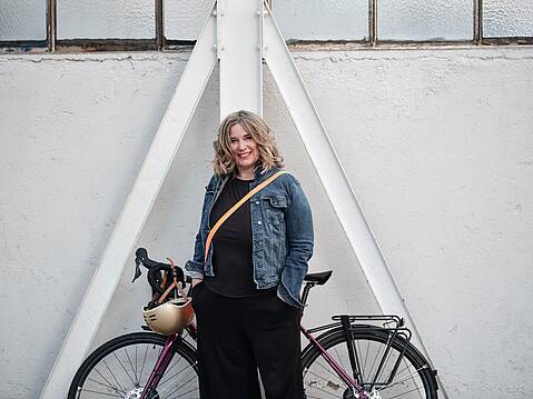 Bild von xelware: Frau in Jeansjacke, die vor ihrem City Bike steht